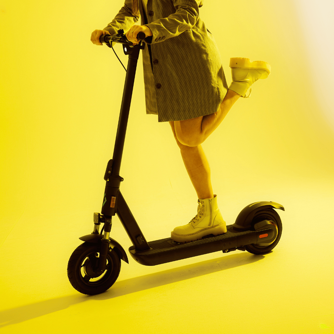 LOCO Motion Pro electric scooter with rider against yellow backdrop