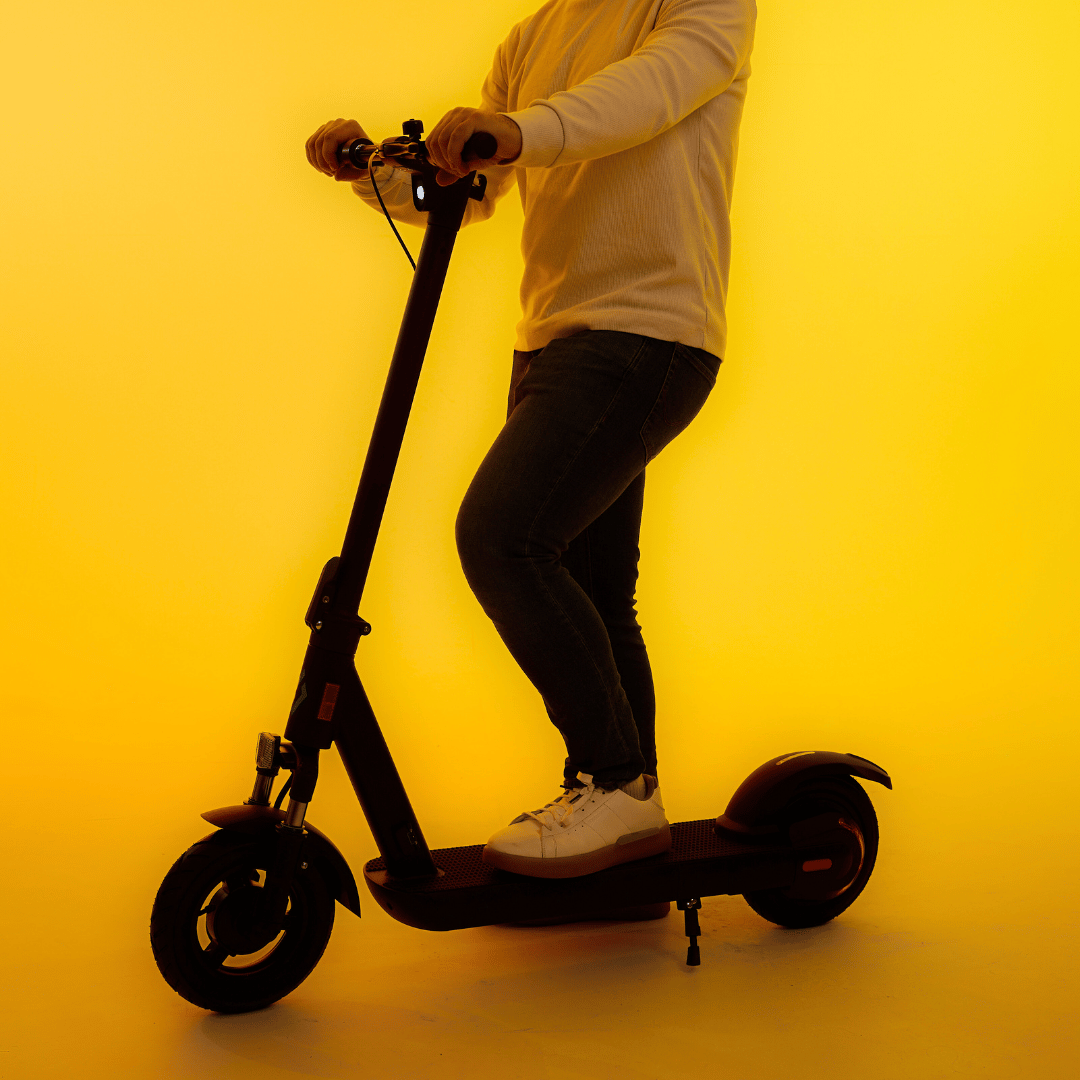 Person riding the LOCO Motion Pro electric scooter in studio lighting
