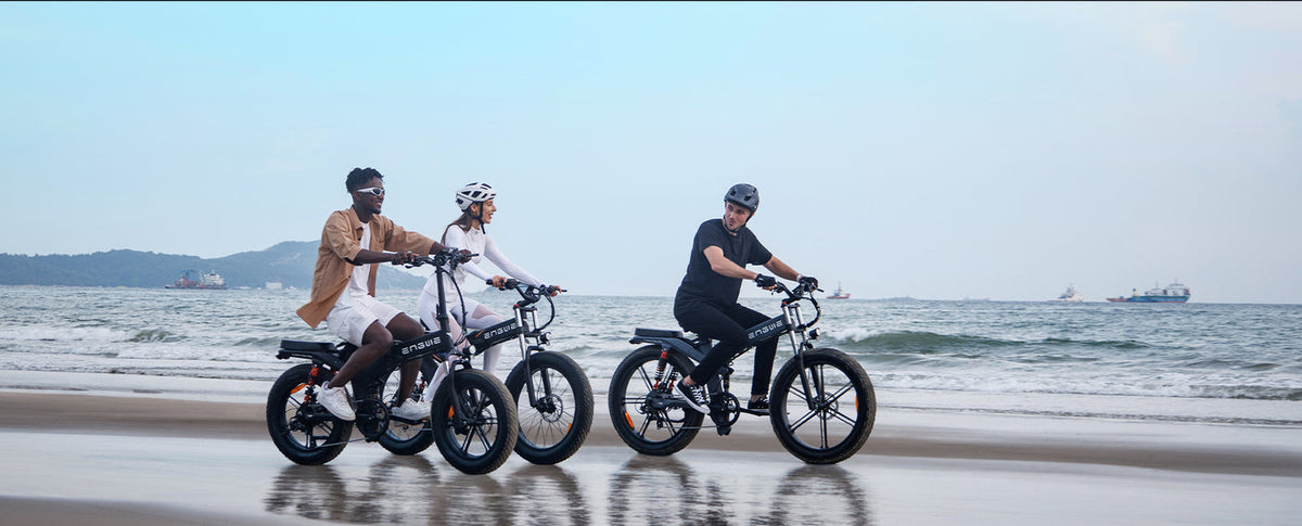 Two riders on Engwe X range e-mopeds by the sea